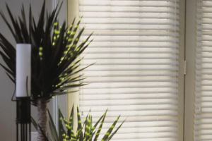 A close up of white faux wooden blinds