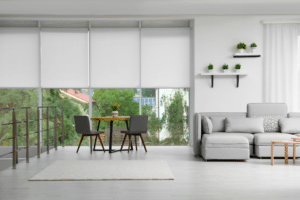 Motorized, white roller shades are featured in a modern living and dining room
