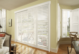 A sliding glass door with shutters.